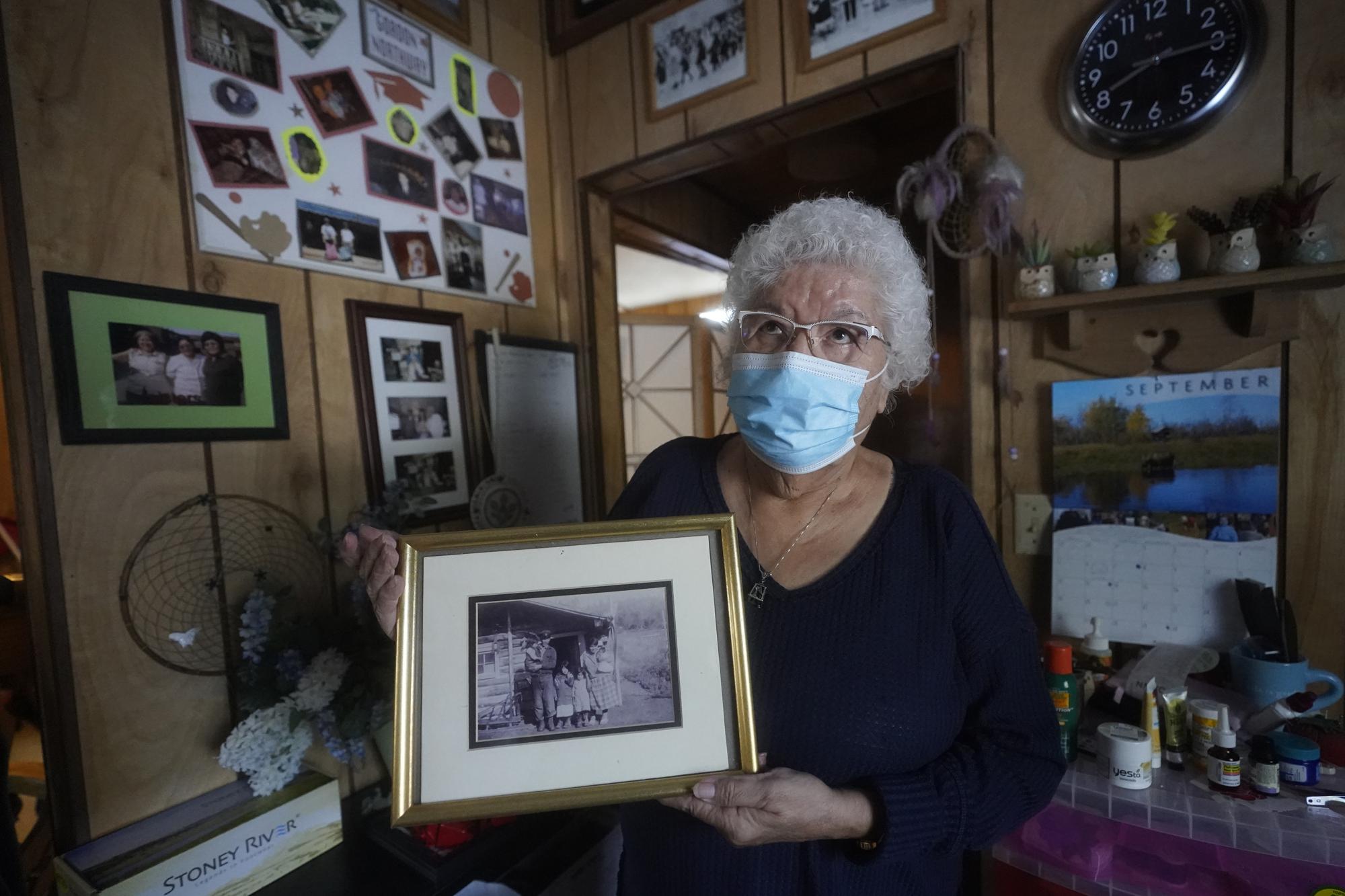 Daisy Northway holds an undated photograph of her parents at her home Wednesday, Sept. 22, 2021, in Tok, Alaska. Northway speaks from first-hand knowledge when advocating that people get vaccinated for COVID-19. Her family came from Healy Lake, located about 70 miles northwest of Tok. The small village's population was almost entirely wiped out by a smallpox epidemic in 1947. "My mother and dad had to bury my mother's parents and three of their children in a mass grave because they were so tired," she said. (AP Photo/Rick Bowmer)